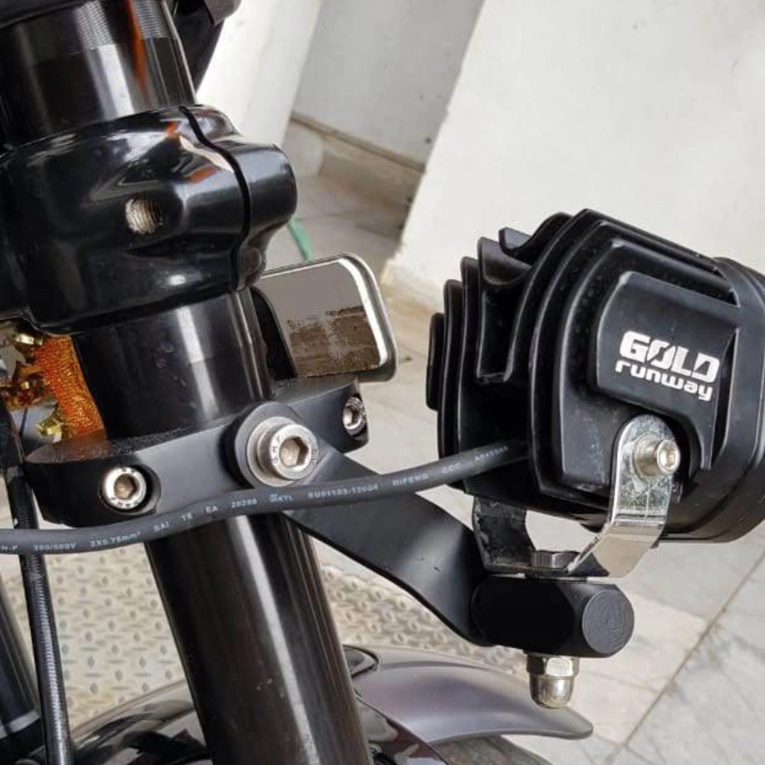 Close-up of motorcycle auxiliary light mounting hardware near the handlebar