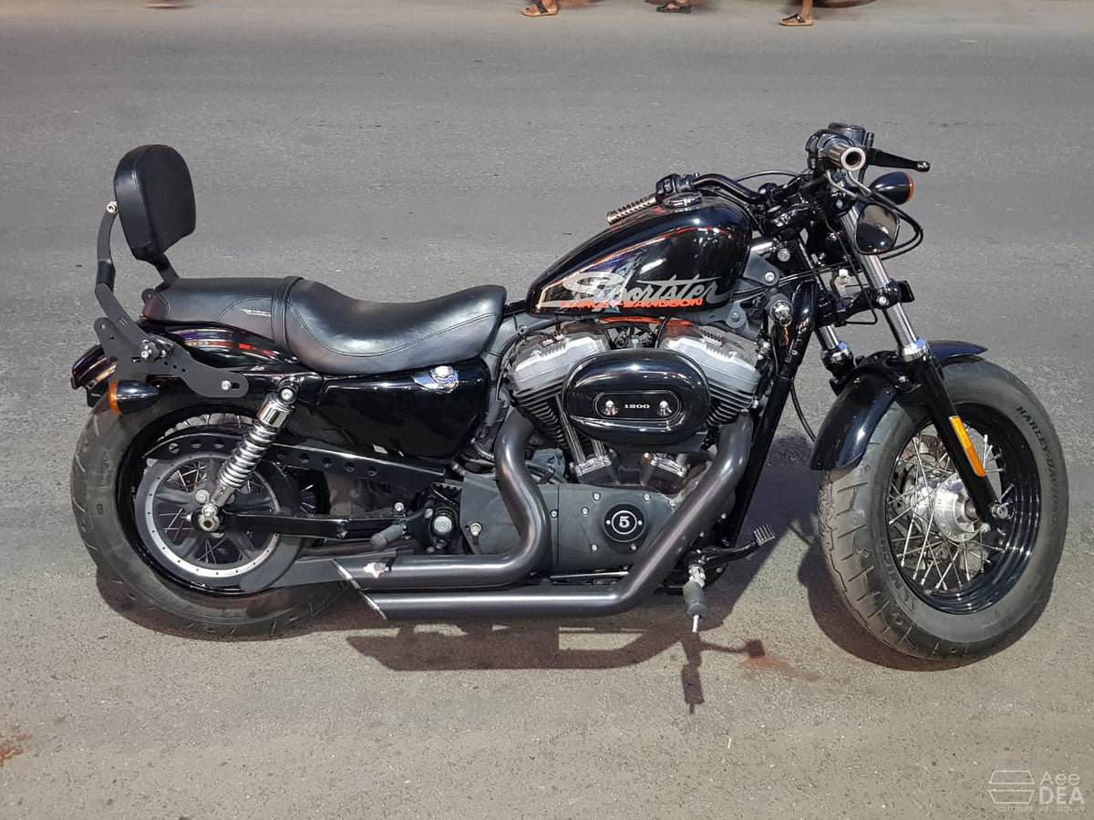 Cruiser motorcycle with adjustable backrest positioned behind the rider