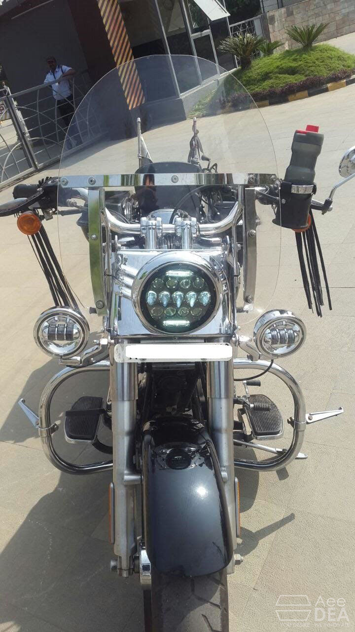 Front view of a motorcycle fitted with a clear adjustable windshield and metal mounting brackets