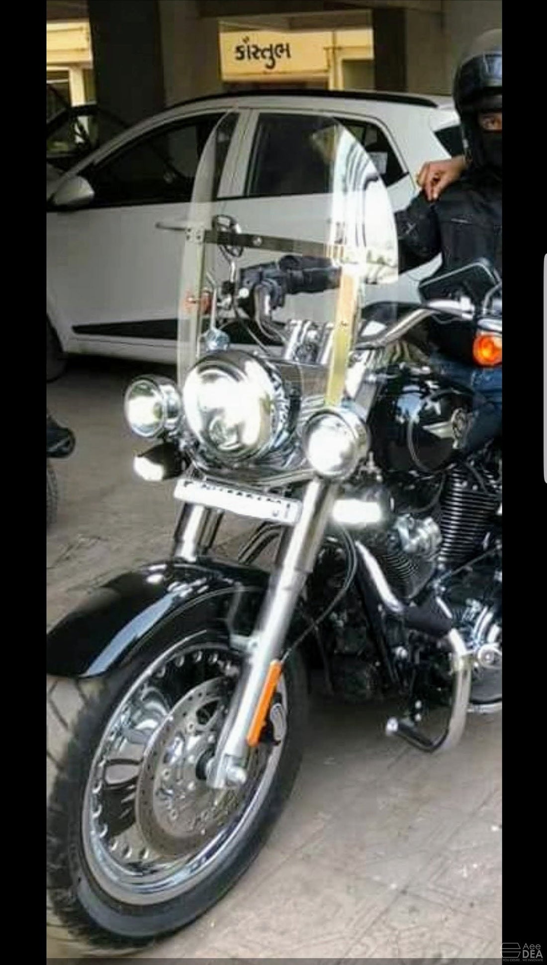 Front view of a motorcycle fitted with a clear adjustable windshield and metal mounting brackets