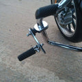 Adjustable black highway footpeg fitted to a motorcycle engine guard