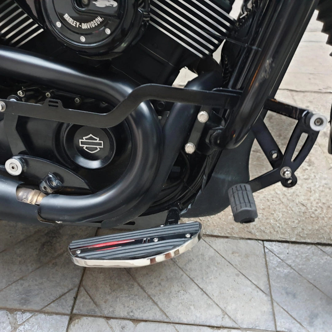 Close-up of motorcycle footboard positioned beside the engine casing