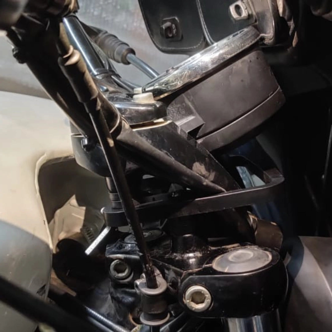 Close-up of AeeDEA handlebar reach extender mounting bracket installed on a motorcycle
