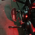 Motorcycle pillion footboard with illuminated LED visible in low-light conditions