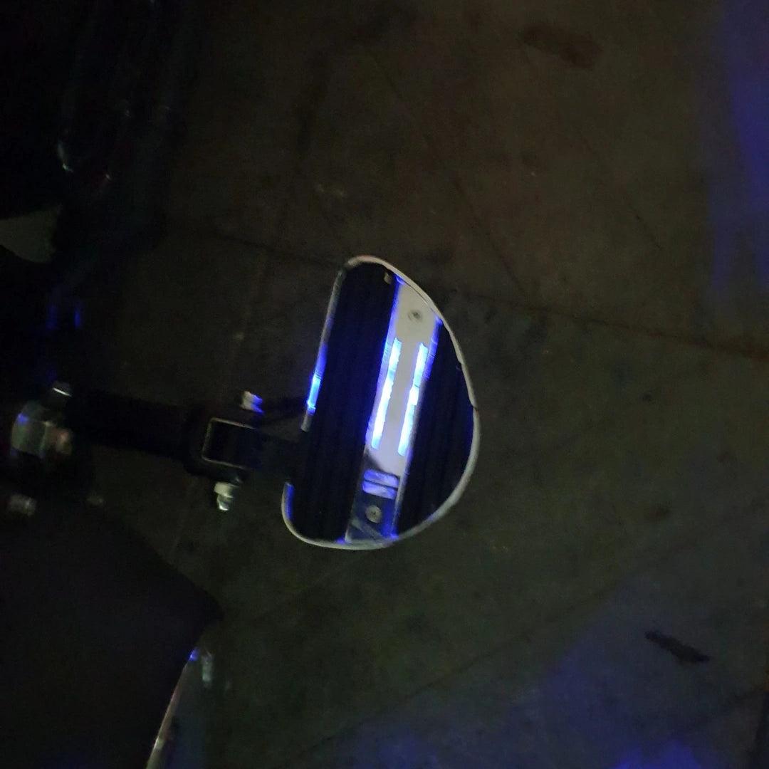 Side detail of an illuminated motorcycle mid-mount footboard