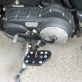 Mid-mount rider footboards shown beside the motorcycle engine
