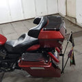 Rear side view of motorcycle fitted with a red touring pannier and luggage mounting system