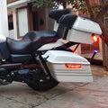 Close-up of white touring side pannier mounted beside the motorcycle rear wheel