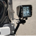 Close-up of an auxiliary light attached to a motorcycle fork mount