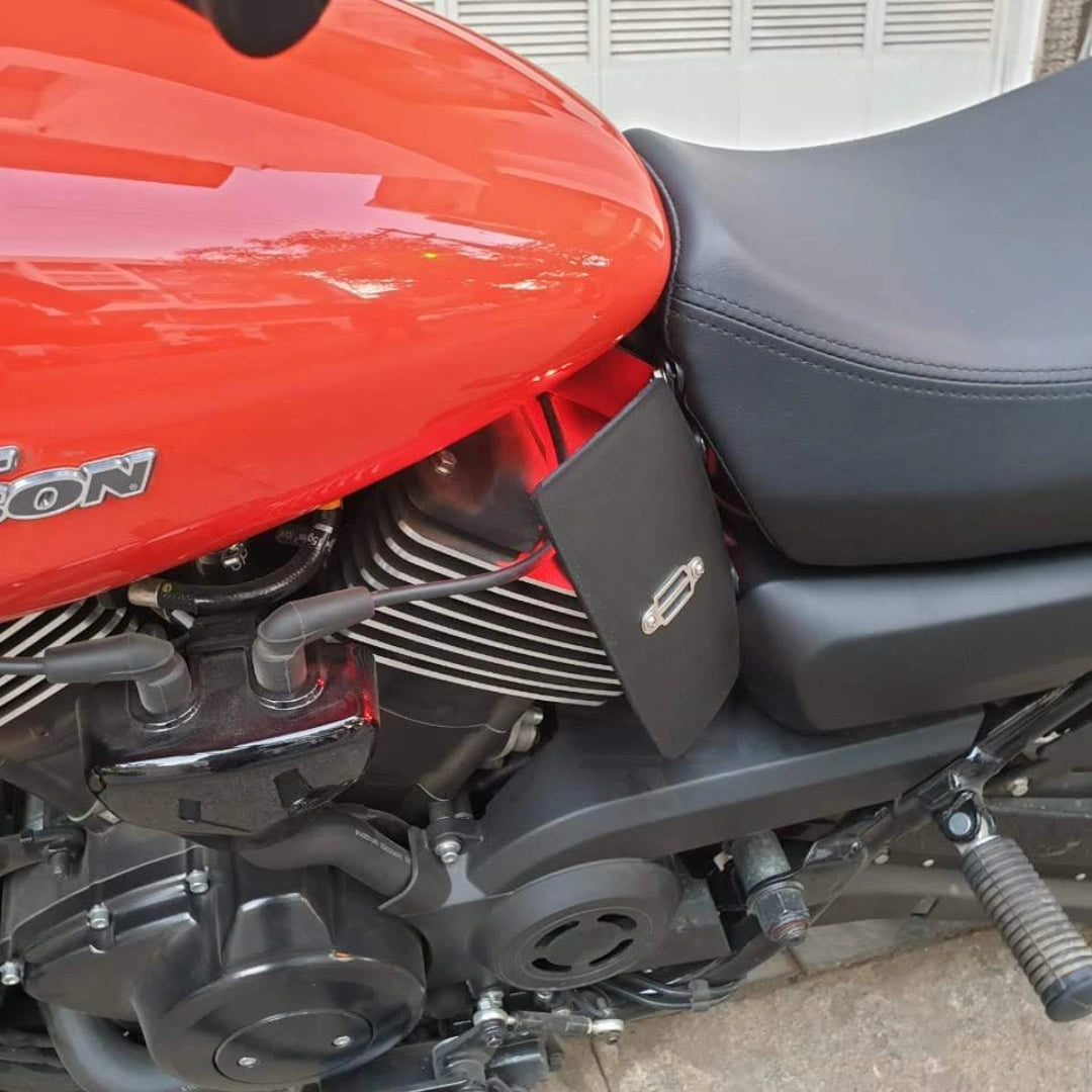 Close-up of a black heat deflector installed between the fuel tank and engine on a red motorcycle
