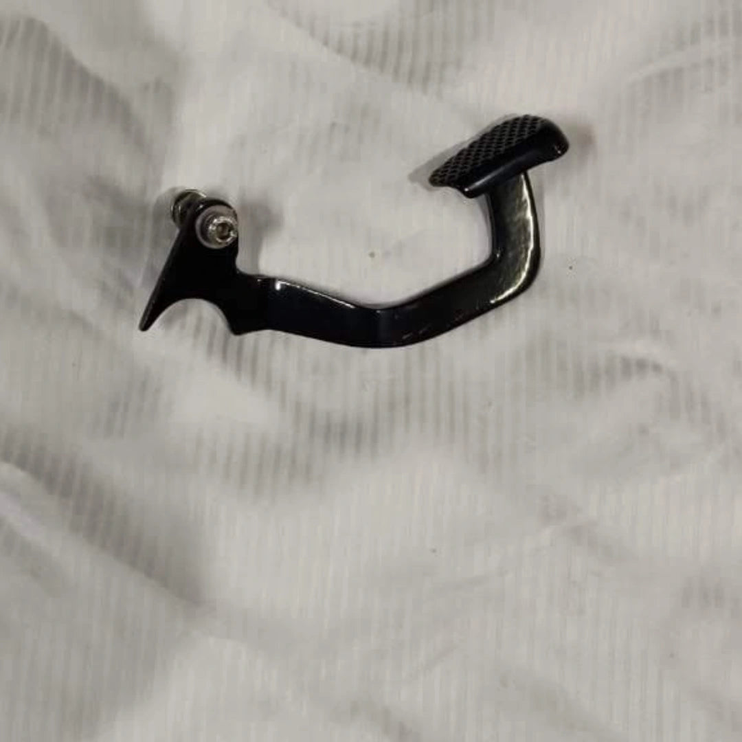 Close-up of a motorcycle heel shifter fitted beside the foot control, with a rider demonstrating its position