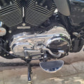 Close-up of chrome motorcycle rider footboard beside the engine
