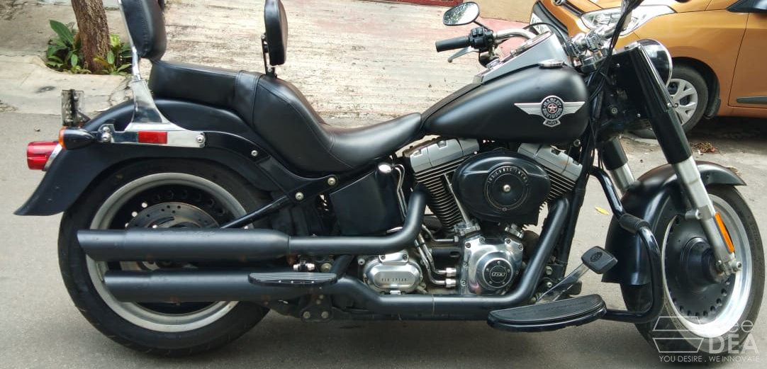 Deep-resting motorcycle seat with rider backrest installed on a black cruiser motorcycle