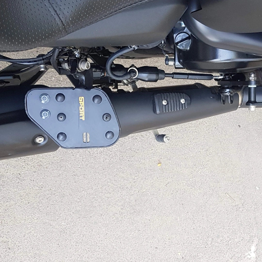 Side view of foldable motorcycle rider footboard mounted below the engine