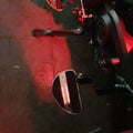 Close-up of motorcycle footboard area illuminated by red lighting