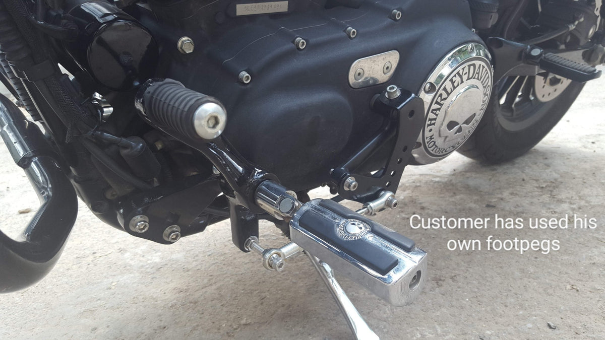 Forward foot controls and connecting linkage installed beside a motorcycle engine