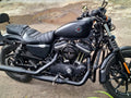 Front mud deflector installed beside the front wheel and fork of a black motorcycle