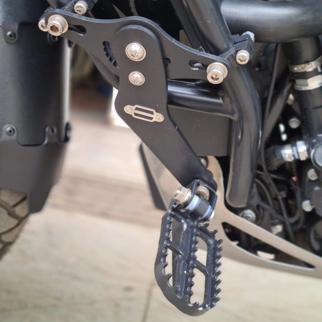 Close-up of AeeDEA adjustable extended reach footpeg mounted to an OEM Harley-Davidson crash bar