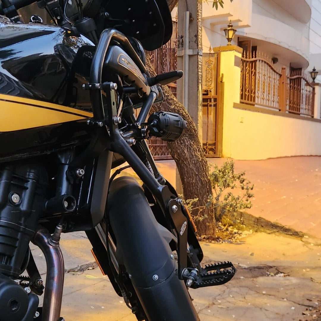 Close-up of AeeDEA highway footpeg mounting bracket near the engine guard on Himalayan 450