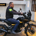 Rider resting feet on AeeDEA extended highway footpegs while seated on Royal Enfield Himalayan 450