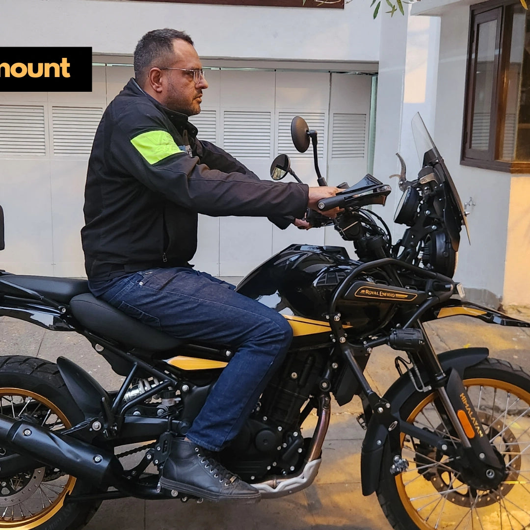 Rider resting feet on AeeDEA extended highway footpegs while seated on Royal Enfield Himalayan 450