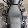 Motorcycle seat viewed from above with mid-mount rider footboards visible on both sides