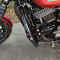 Close-up of the steel crash guard fitted beside the motorcycle engine