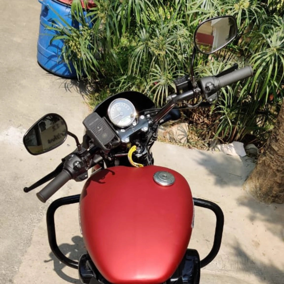 Top view of a red motorcycle showing the fuel tank, handlebar and front guard area