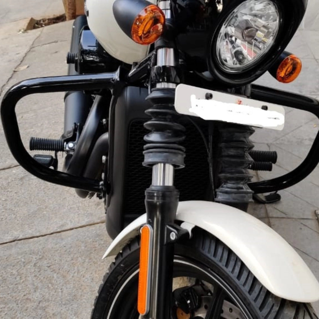 Front close-up of a motorcycle showing the headlight, front forks and crash guard