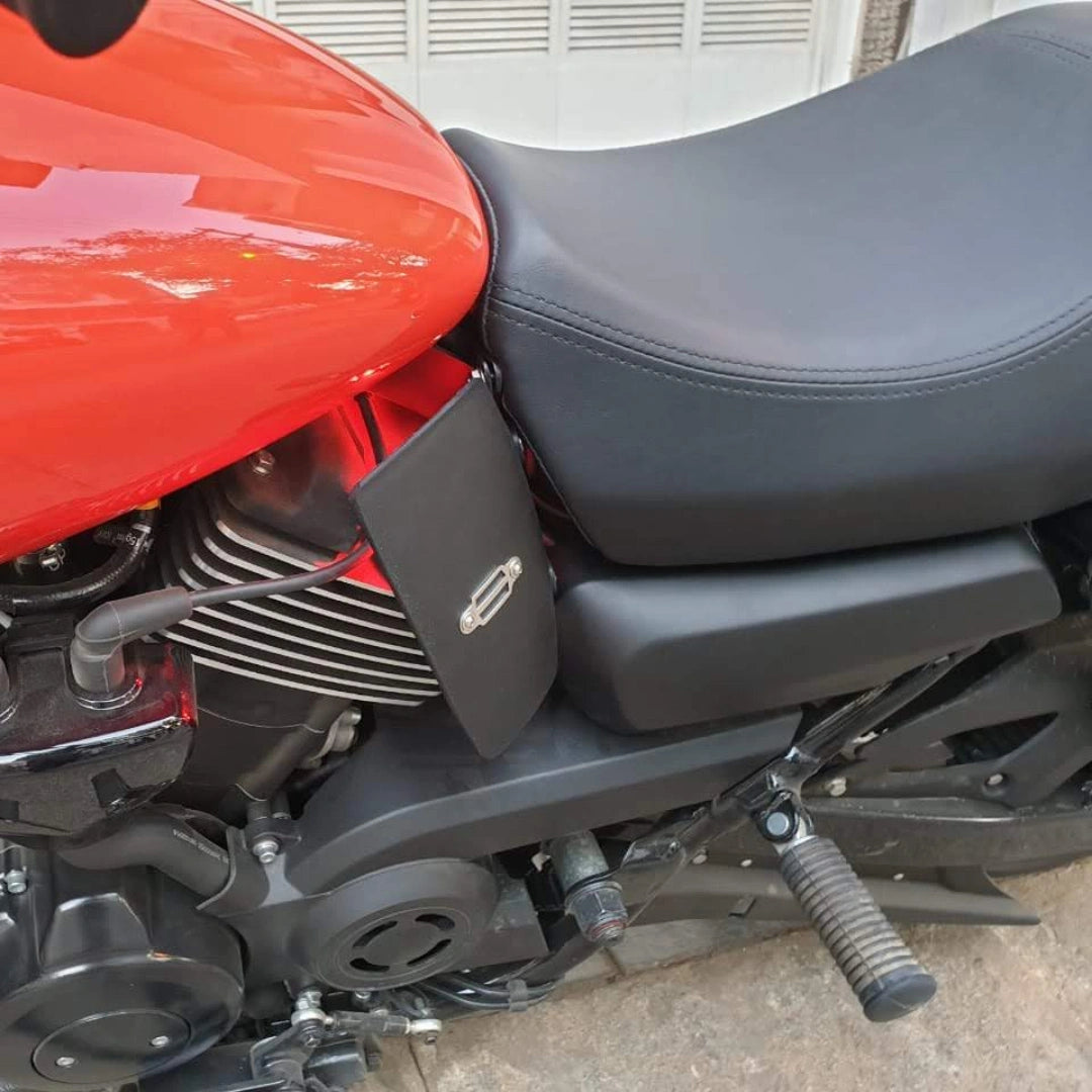 Side close-up showing the position of a black heat deflector beside the motorcycle engine