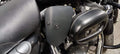 Close-up of a black heat deflector shield mounted beside the motorcycle engine