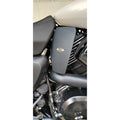 Black heat deflector fitted beside the engine on a white motorcycle
