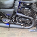 Close-up of a motorcycle engine area with blue LED illumination around the fitted heat deflector