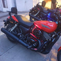 Red motorcycle with black heat deflector fitted beside the engine and below the fuel tank