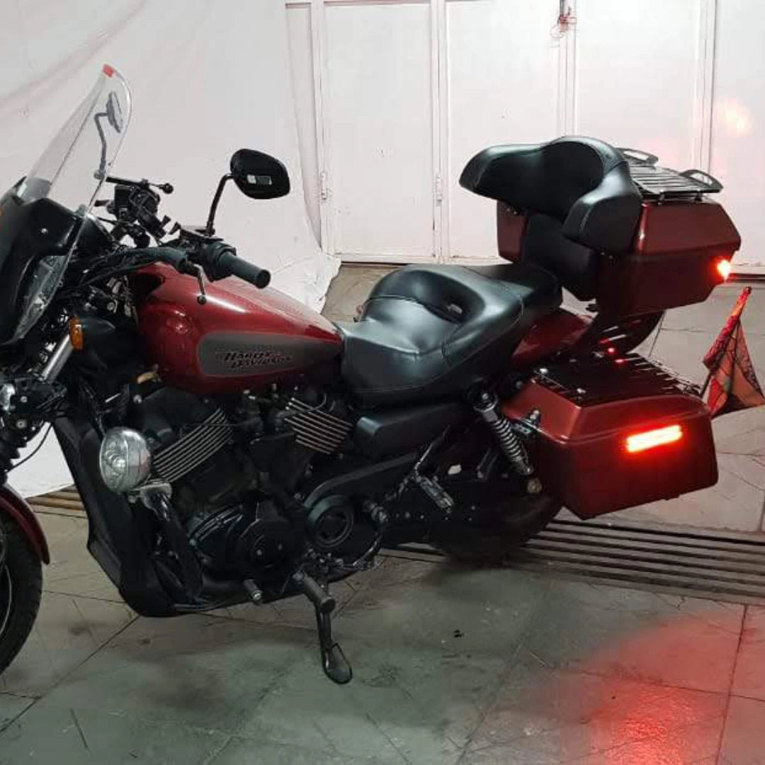 Dark motorcycle fitted with touring side panniers and illuminated rear LED lighting