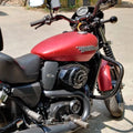 Side view of a red motorcycle fitted with a black steel engine guard