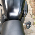 Close-up of motorcycle rider footboard installation near the fuel tank and seat