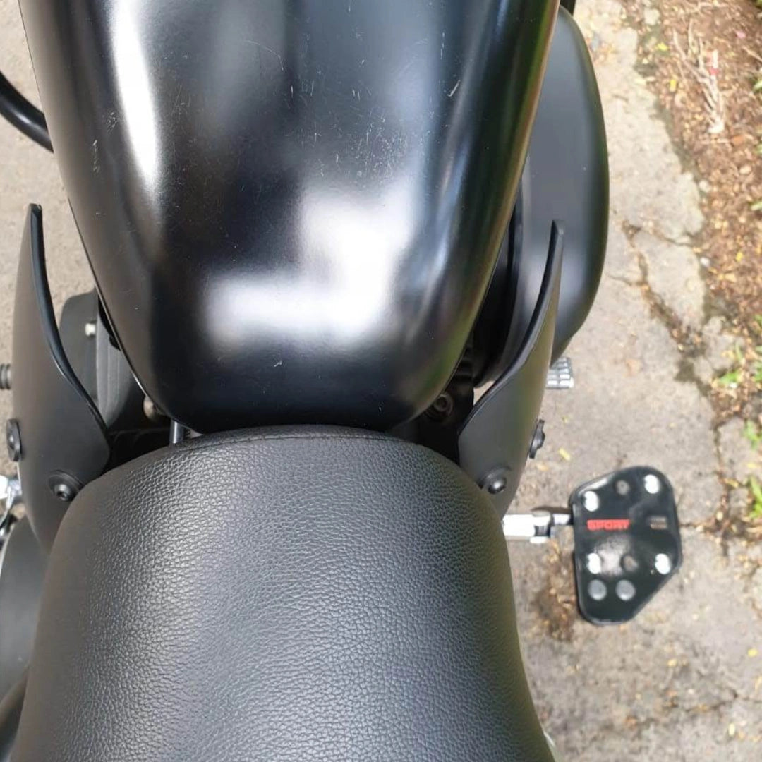 Close-up of motorcycle rider footboard installation near the fuel tank and seat