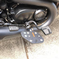 Close-up of Sports-style motorcycle rider footboard beside the engine