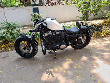 Harley-Davidson Sportster with a raised fuel tank and black tank raiser installed