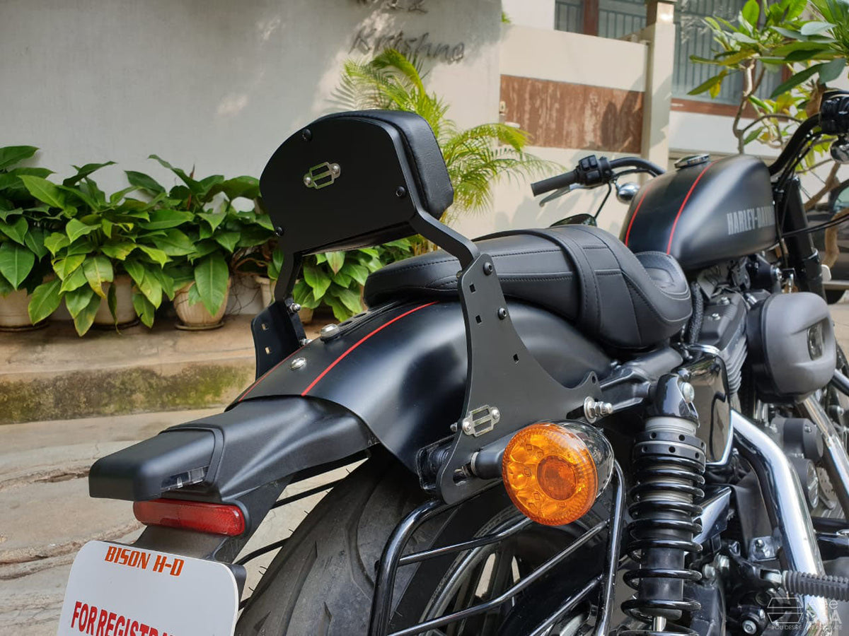 Tall pillion backrest mounted behind the seat of a black cruiser motorcycle