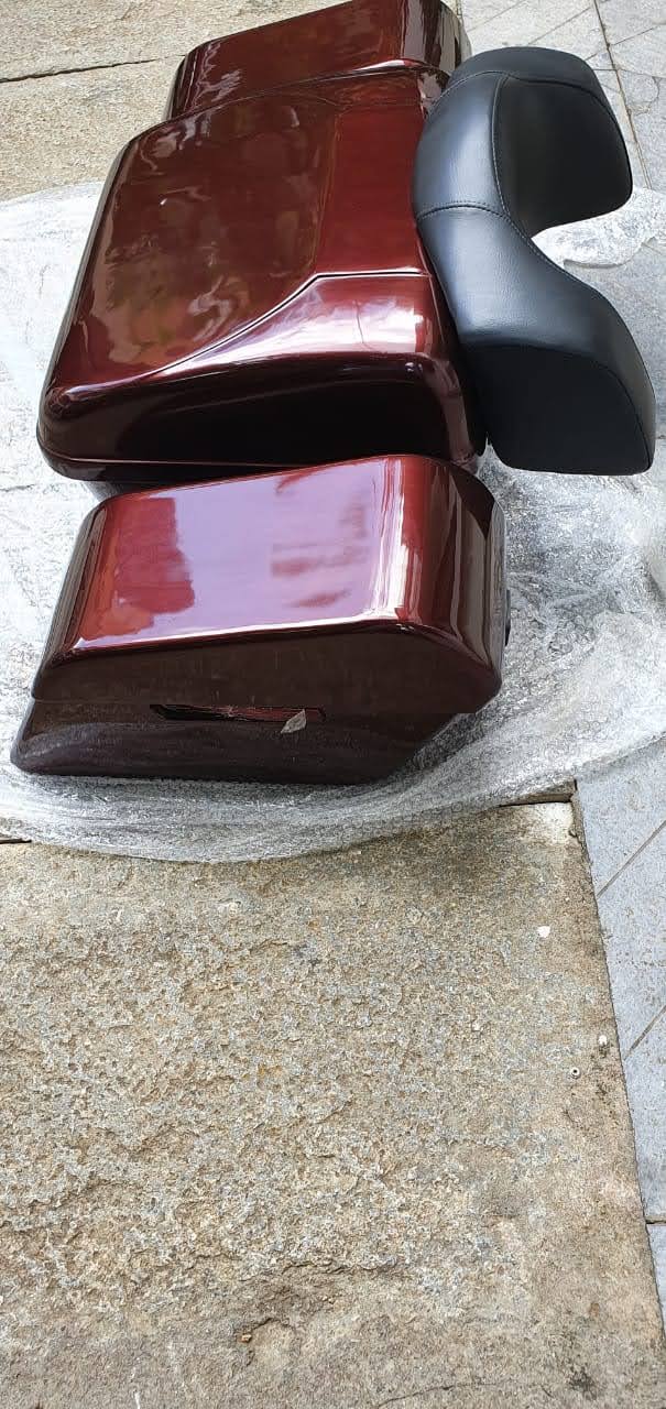 Pair of glossy maroon touring pannier boxes shown with a black backrest
