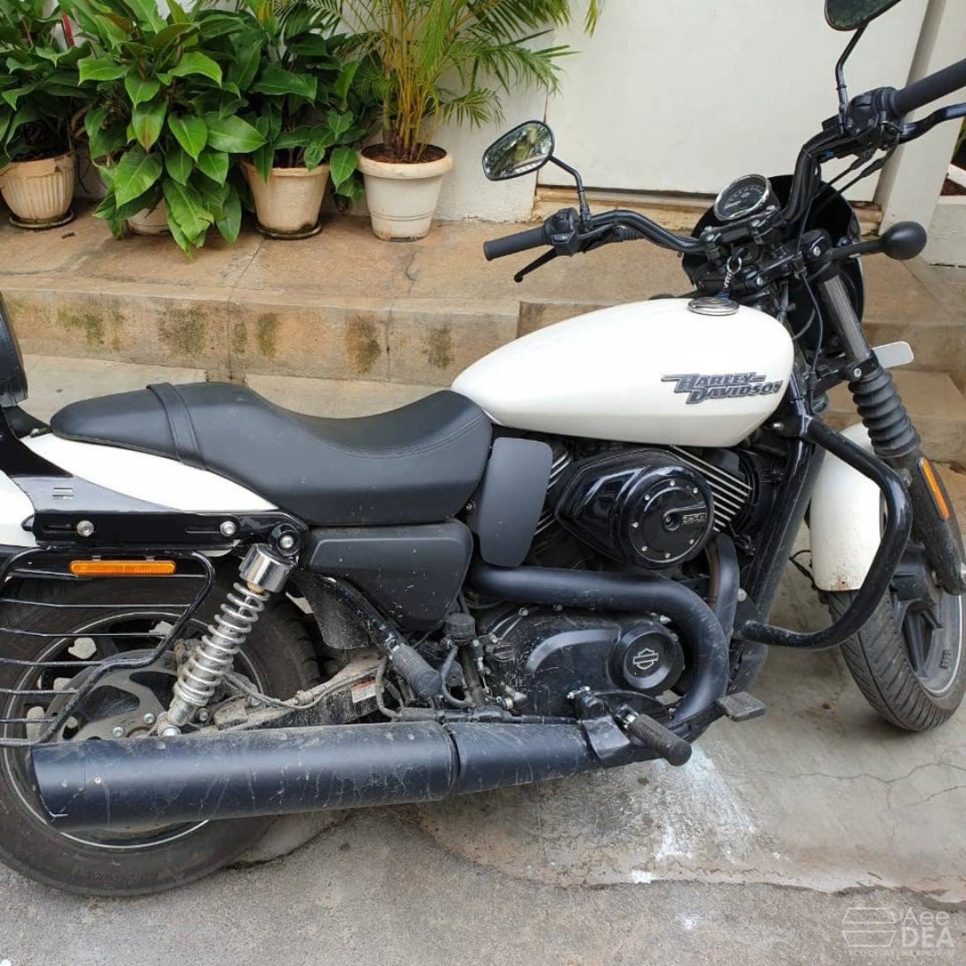 Side view of a white motorcycle with a black steel engine guard fitted
